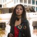 Stylish woman in vibrant attire against historic Puebla, Mexico cityscape.