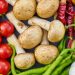 A vibrant assortment of fresh vegetables and mushrooms arranged in a flat lay.